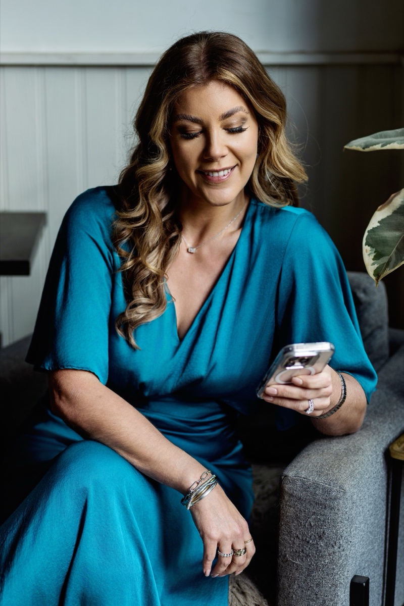 Business owner in teal using her phone