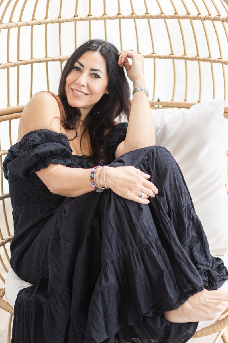 Relaxed personal brand portrait of a woman in a wicker chair