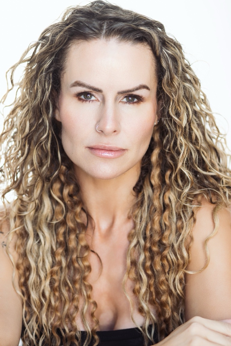 Natural light headshot of a woman with curly hair