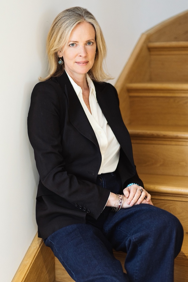 Professional portrait of a woman seated on wooden stairs