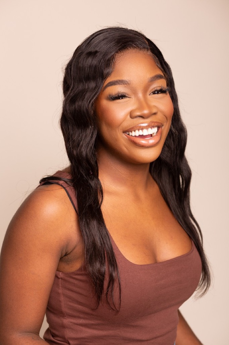 Confident studio headshot with a warm expression